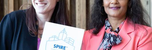 Two women from UL and MRP Realty hold up SPIRE plaque. 